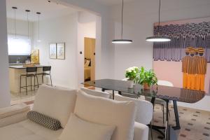 a dining room with a table and white chairs at AD ASTRA Comfort Living in Preveza