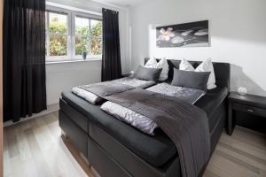 - une chambre dotée d'un lit avec un cadre noir dans l'établissement Apartment Emsköpken, à Norderney