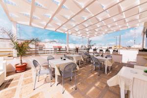 Un restaurante con mesas y sillas en un balcón. en LORY'S HOUSE, en Porto Cesareo