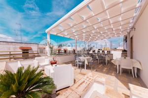 Un balcón de un restaurante con mesas y sillas. en LORY'S HOUSE, en Porto Cesareo