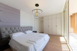 パリアーサにあるVilla Horizon Palasëのベッドルーム(ライト付きの白い大型ベッド1台付) +8枚の写真