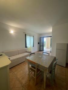a living room with a table and a couch at Appartamento Favoloso in Tergu