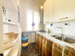 a kitchen counter with a sink and a window at Appartamento da Gigi a Marina di Cecina by Zoom In Earth in Marina di Cecina