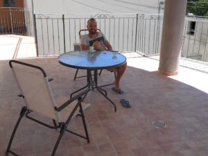 a man sitting at a table next to a chair at GiaMia Villas -Rural Central Italy Paradise in Sulmona