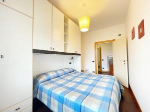 a bedroom with a bed with a blue and white blanket at Appartamento da Gigi a Marina di Cecina by Zoom In Earth in Marina di Cecina