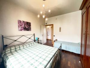 a bedroom with a bed with a green and white comforter at Appartamento da Gigi a Marina di Cecina by Zoom In Earth in Marina di Cecina