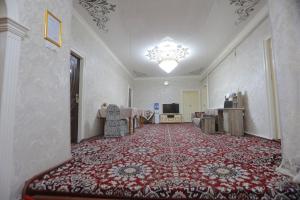 a hallway with a room with a red carpet at Musobek Guest House in Khiva