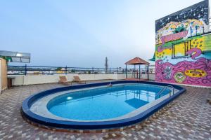 a swimming pool on top of a building with a mural at 4 BHK Luxury Penthouse- Sliceinn Velvet, Wilson Garden, Bangalore in Bangalore