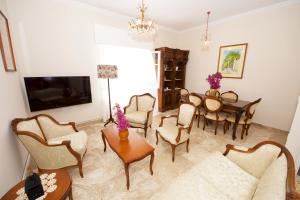 Una sala de estar con un sofá, una mesa y sillas. en Casa Lamacchia by CorfuEscapes, en Corfú