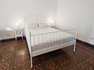 a white bed in a room with two tables at Almarè House in Giardini Naxos