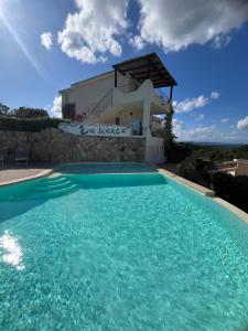 a swimming pool in front of a villa at Casa Stella Residence Ea Bianca Baja Sardinia in Baja Sardinia