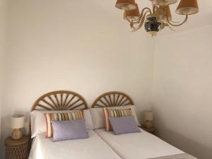 ein Schlafzimmer mit zwei Betten und einem Kronleuchter in der Unterkunft O lar da praia in Corcubión