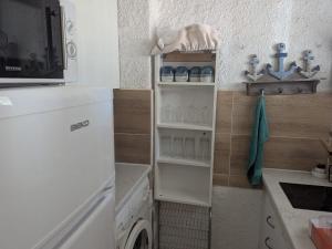 a small kitchen with a washer and dryer at TRESOR LITTORAL, belle vue direct plage in Argelès-sur-Mer