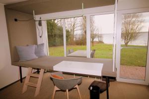 a room with a bed and a table and a window at Fewo-Suite Seeblick mit Terrasse in Ascheberg