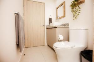 a white bathroom with a toilet and a mirror at El Prado: New 2br Condo in Las Catalinas in Playa Danta +69 photos