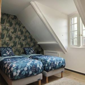 a bedroom with two beds and a staircase at Magnifique villa au cœur de la nature in Marigny-en-Orxois