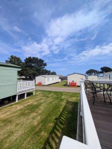 Isle of WightにあるBembridge Hideaway Static Caravan - Sandhills Holiday Park with Private Beachのデッキ(テーブル、ピクニックテーブル付)