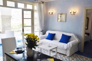 sala de estar con sofá blanco y almohadas azules en L'Atelier del Pittore Apartment, en Taormina