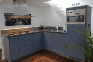 a kitchen with blue cabinets and a sink at B&B Panorama in Arnhem
