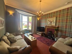 a living room with two couches and a fireplace at Gruinard Guest House in Beauly