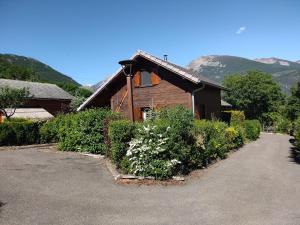 a wooden house with a lot of plants in front of it at CHALET MONTAGNE CLASSÉ 3 ETOILES ALPES QUEYRAs in Guillestre