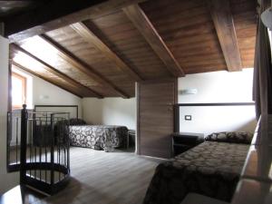 a bedroom with two beds and a wooden ceiling at Affittacamere Al Cantoun in Chiomonte