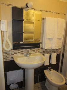a bathroom with a sink and a toilet and towels at Affittacamere Al Cantoun in Chiomonte