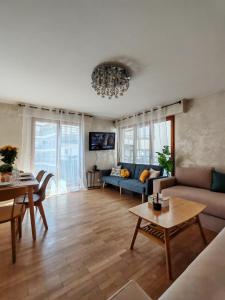 a living room with a couch and a table at Élégance, parking gratuit & à 3 min à pied du Metro in Clichy