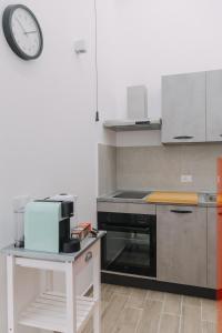 a kitchen with a stove and a clock on the wall at Serenello Home in Palermo
