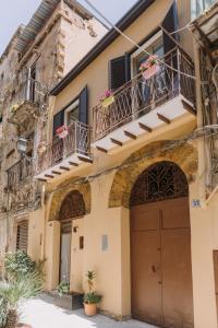 an old house with balconies and a garage at Serenello Home in Palermo