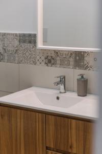 a bathroom with a white sink and a mirror at Serenello Home in Palermo