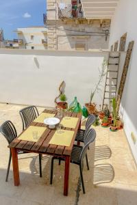 een houten tafel en stoelen op een terras bij L'Ancora appartamenti 5 in Giovinazzo