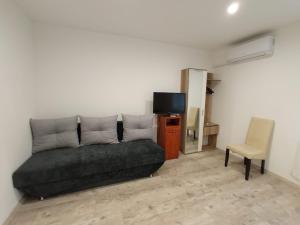 ein Wohnzimmer mit Sofa und Fernseher in der Unterkunft Pyramids Piramis Vendeghaz in Magyarbóly