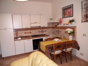 cocina con mesa y cocina con armarios blancos en La Scaletta, en Agrigento