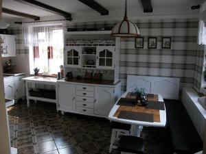 a kitchen with white cabinets and a table at Dom z Ogrodem Darłowo do 10 osób ! in Darłowo