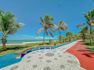 a pathway leading to the beach with palm trees at GB03 Maravilhosa Casa 5 Suítes a 200m da Praia in Guarajuba