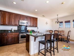 a kitchen with wooden cabinets and a table with chairs at 3-Bedroom El Dorado Ranch San Felipe Rental with Beach View in Playa El Paraíso