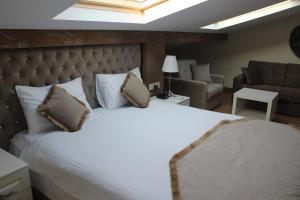 a bedroom with a large white bed and a couch at Diamond Royal Hotel in Istanbul