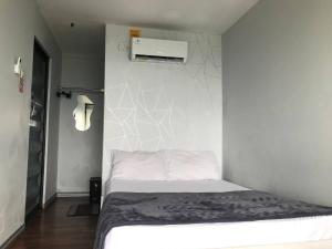 a bedroom with a bed and a white wall at Contana By Travelink in Patuk +33 photos