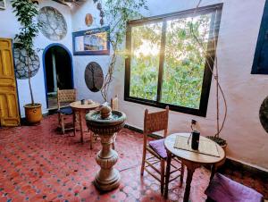 a room with tables and chairs and a window at Mandalahome in Marrakesh