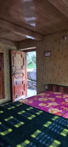 a room with a bed and a rug on the floor at Blabla House Himachal in Pulga