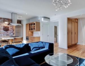 a living room with a blue couch and a glass table at Elevated Living in the Hills in Portland