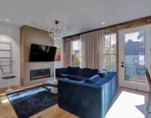 a living room with a blue couch and a fireplace at Elevated Living in the Hills in Portland