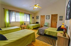 a bedroom with three beds and a ceiling fan at Villa Talanquera in Las Galeras