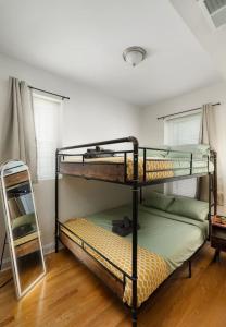 two bunk beds in a room with a mirror at 15mins DT Wicker Park Gem Sleeps 7 FreePark in Chicago