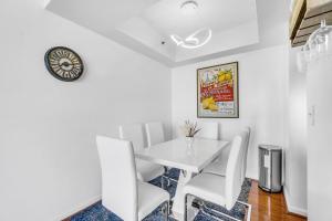 マイアミにあるCity-View Retreat in Brickell 2BR and Free Parkingのダイニングルーム(白いテーブル、白い椅子付)