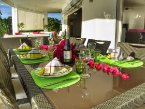 a table with green plates and glasses and a bottle of wine at Villa Salamandra in Las Galeras