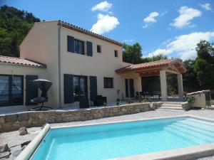 a villa with a swimming pool in front of a house at Coeur de Bonnieux in Bonnieux
