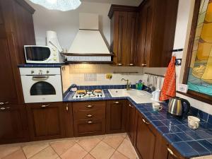 a kitchen with a sink and a stove top oven at Casetta Romana Ampia Casa Vacanze con Giardino & Parcheggio Tranquilla Zona Borghesiana Metro C in Borghesiana 
