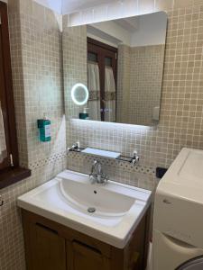 a bathroom with a sink and a mirror at Casetta Romana Ampia Casa Vacanze con Giardino & Parcheggio Tranquilla Zona Borghesiana Metro C in Borghesiana  +28 photos
